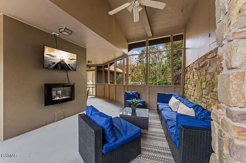 Unwind in your private screened patio with cozy seating, warming fireplace, and peaceful garden views.