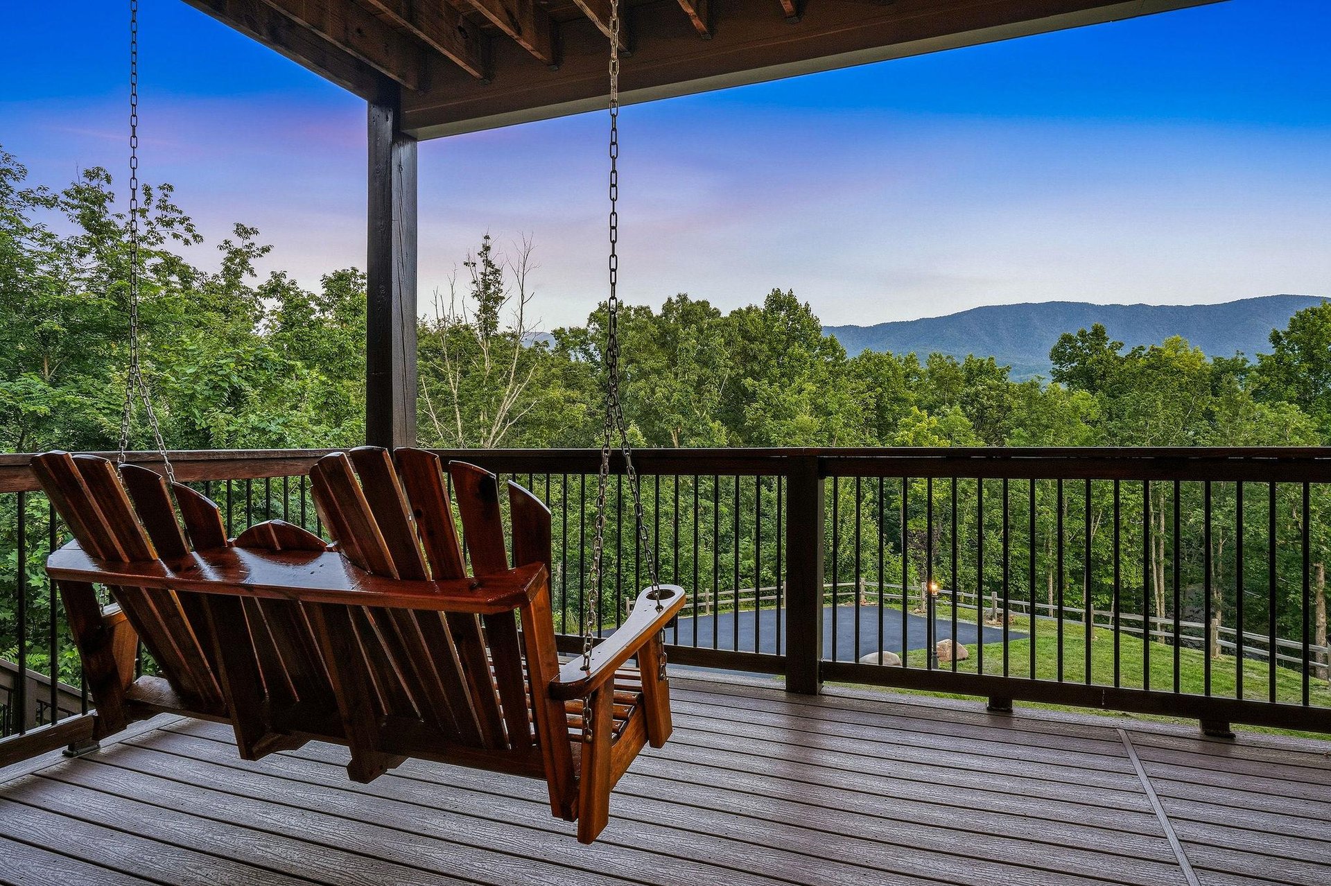 Sink into the porch swing and let your gaze drift across forested hills and distant mountain ridges—your peaceful retreat above the treetops awaits.