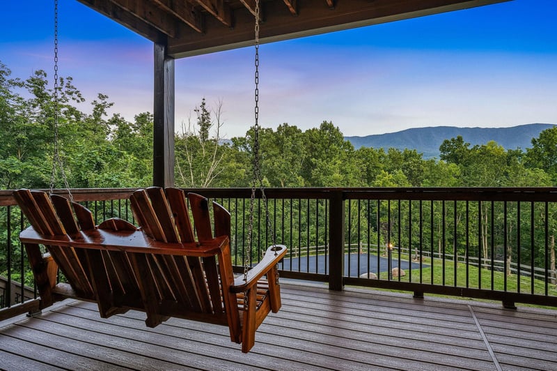 Sink into the porch swing and let your gaze drift across forested hills and distant mountain ridges—your peaceful retreat above the treetops awaits.