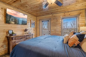 Wake up in rustic luxury with warm wood walls surrounding your comfortable bed and private balcony access for mountain air.