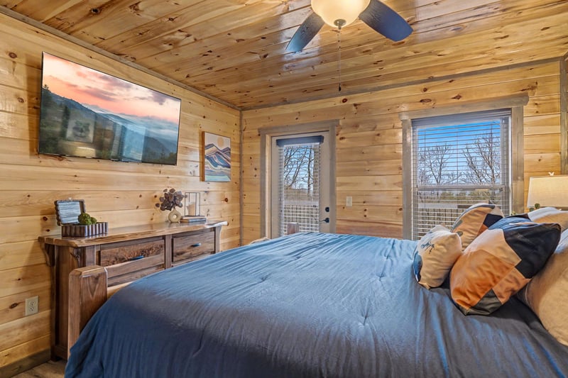 Wake up in rustic luxury with warm wood walls surrounding your comfortable bed and private balcony access for mountain air.