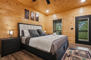 Drift into dreams in this cozy cabin bedroom, where rustic wood walls surround your plush bed and forest views await outside your window.