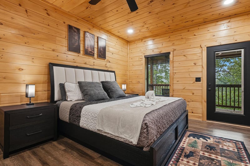 Drift into dreams in this cozy cabin bedroom, where rustic wood walls surround your plush bed and forest views await outside your window.