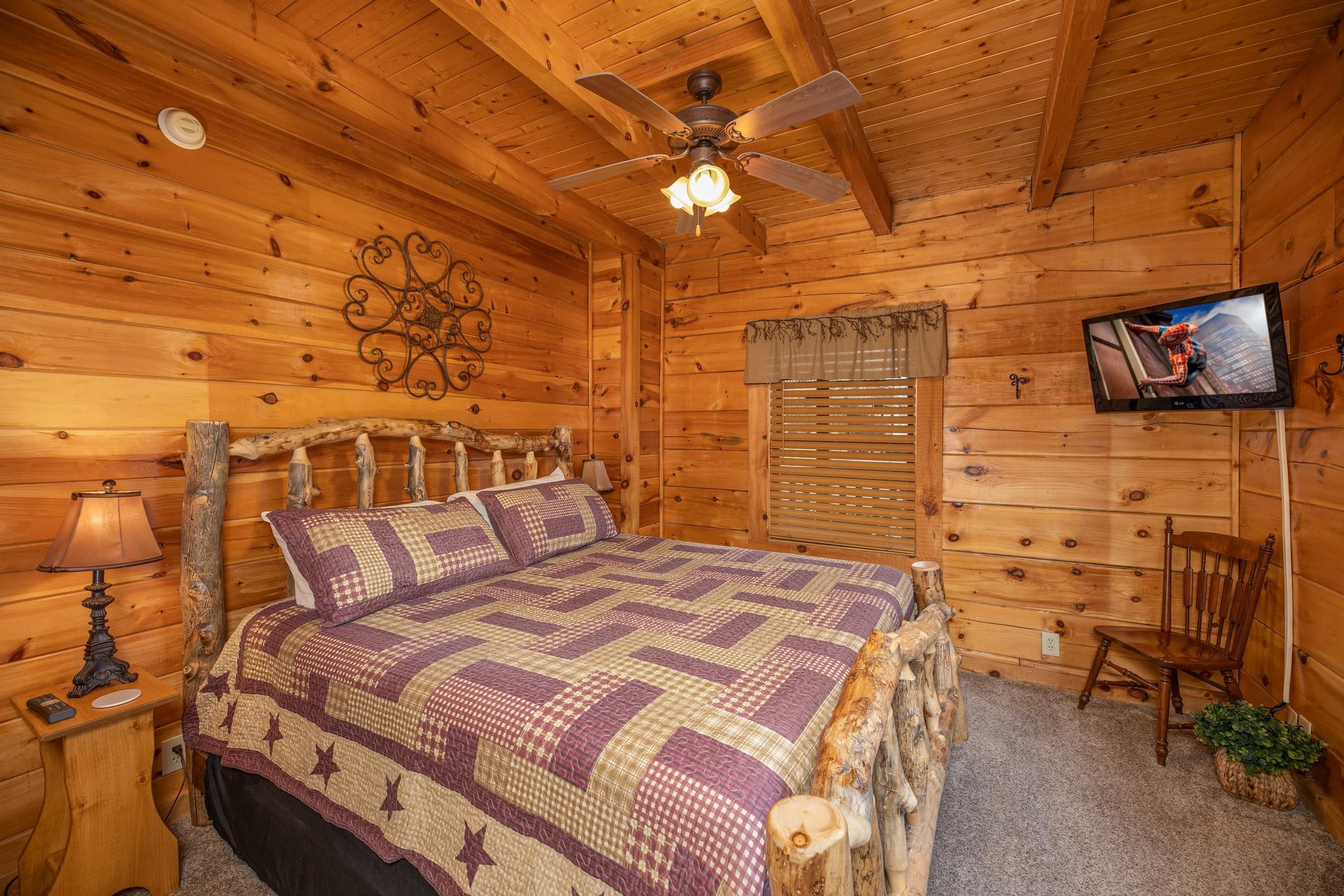 Bedroom with bed, night stands, lamps, and TV at Livin Simple, a 2 bedroom cabin rental located in Pigeon Forge