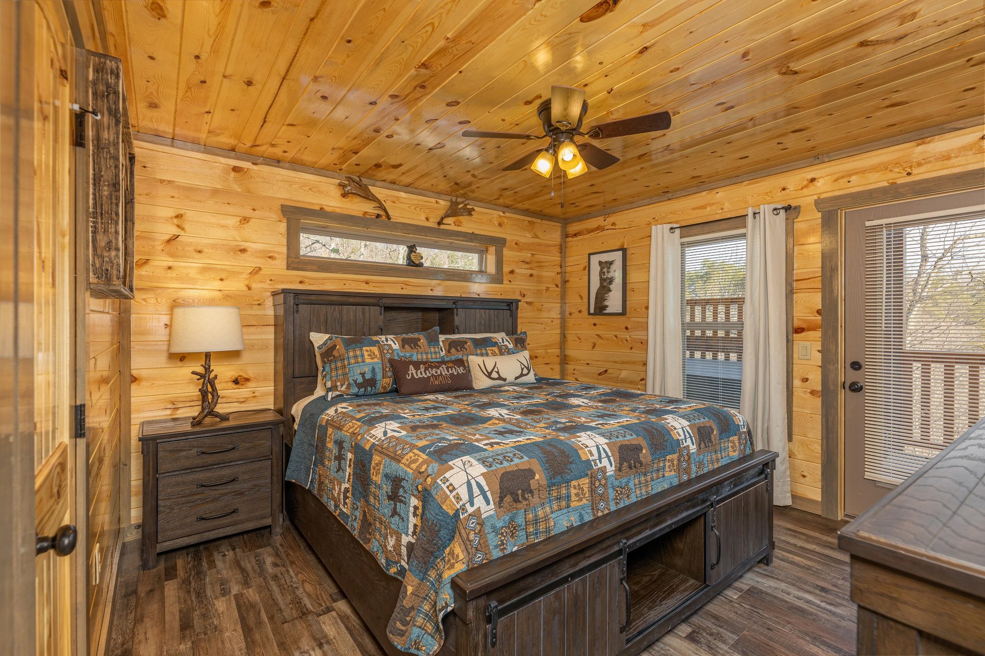 Bedroom with night stand, lamp, and deck access at Everlys Splash, a 4 bedroom cabin rental located in Pigeon Forge