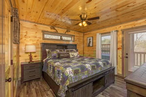 Bedroom with night stand, lamp, and deck access at Everlys Splash, a 4 bedroom cabin rental located in Pigeon Forge