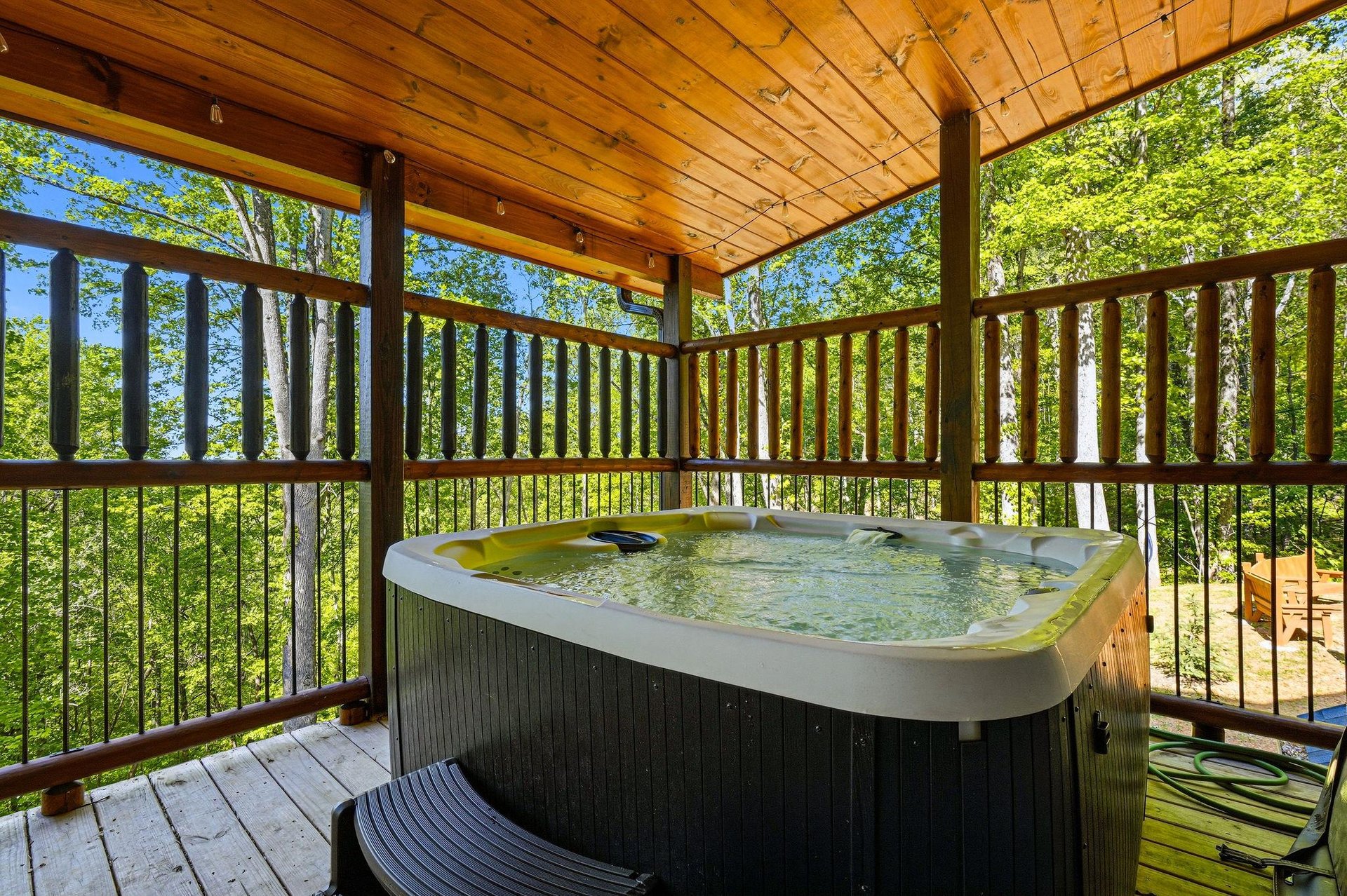 Slip into your private hot tub on this covered deck, surrounded by lush forest canopy for ultimate relaxation.