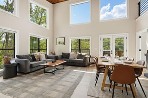 Sunlight floods your openconcept living and dining space through soaring twostory windows. Settle into plush seating, gather around the warm wood dining table, and soak in the peaceful treetop views