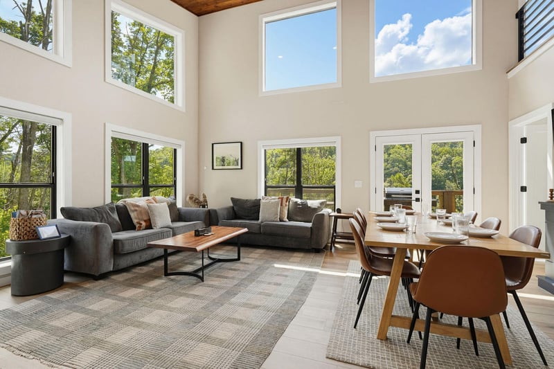 Sunlight floods your openconcept living and dining space through soaring twostory windows. Settle into plush seating, gather around the warm wood dining table, and soak in the peaceful treetop views