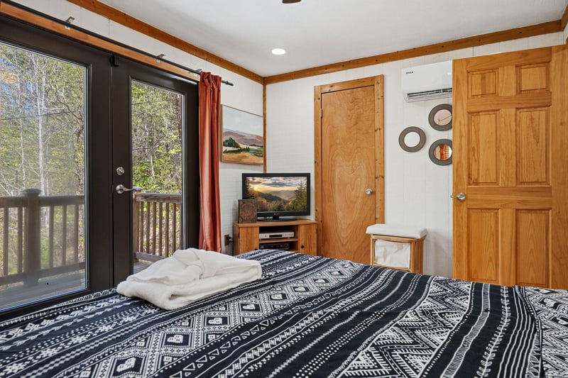 Wake up to forest views through your private balcony doors, where warm wood tones and cozy furnishings create your peaceful mountain retreat.