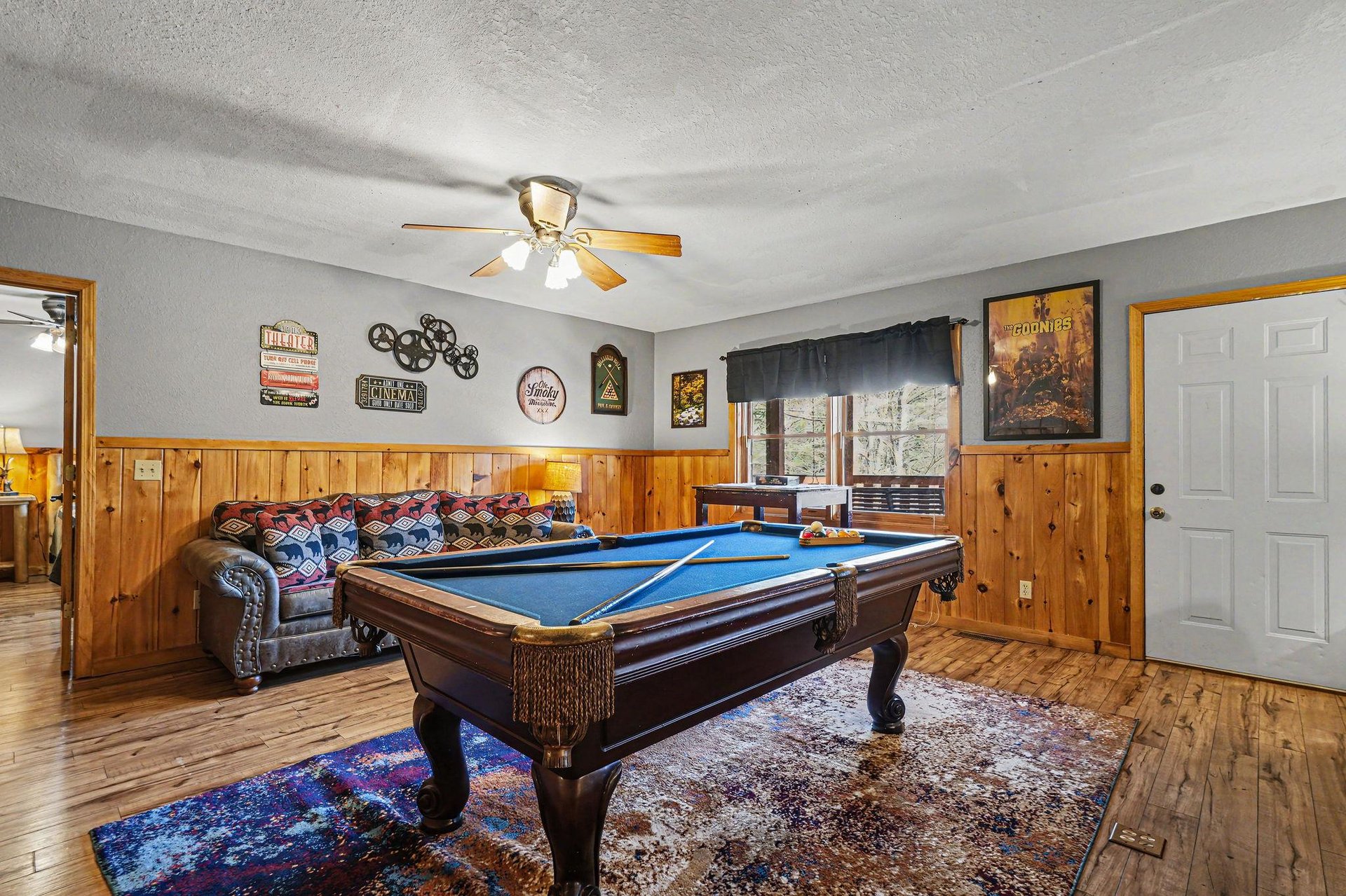 Challenge your friends to a game of pool in this cozy game room with rustic wood paneling and comfortable seating.