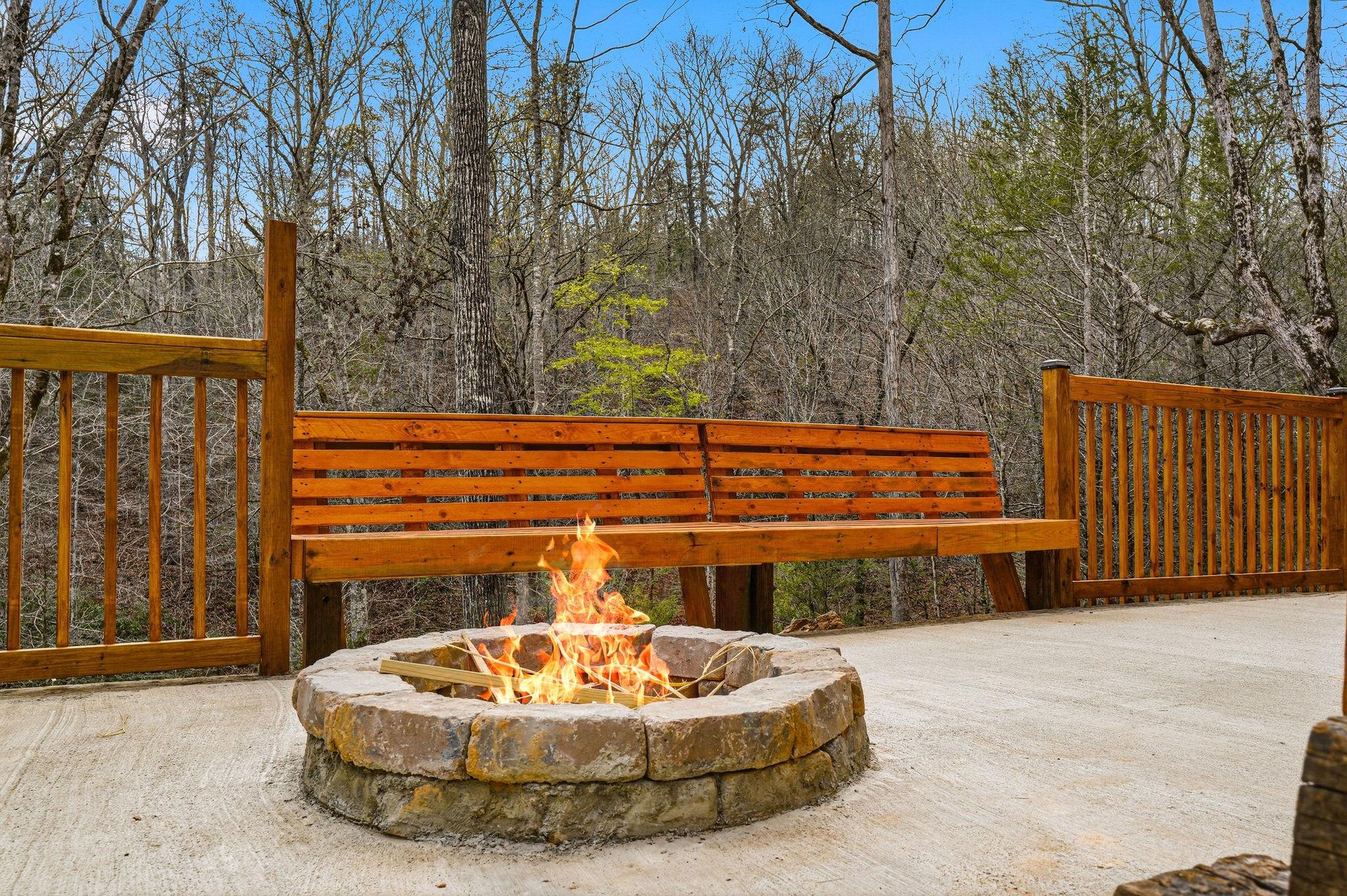 Gather around your private fire pit on the spacious deck, where crackling flames create warmth while you soak in peaceful wooded views.