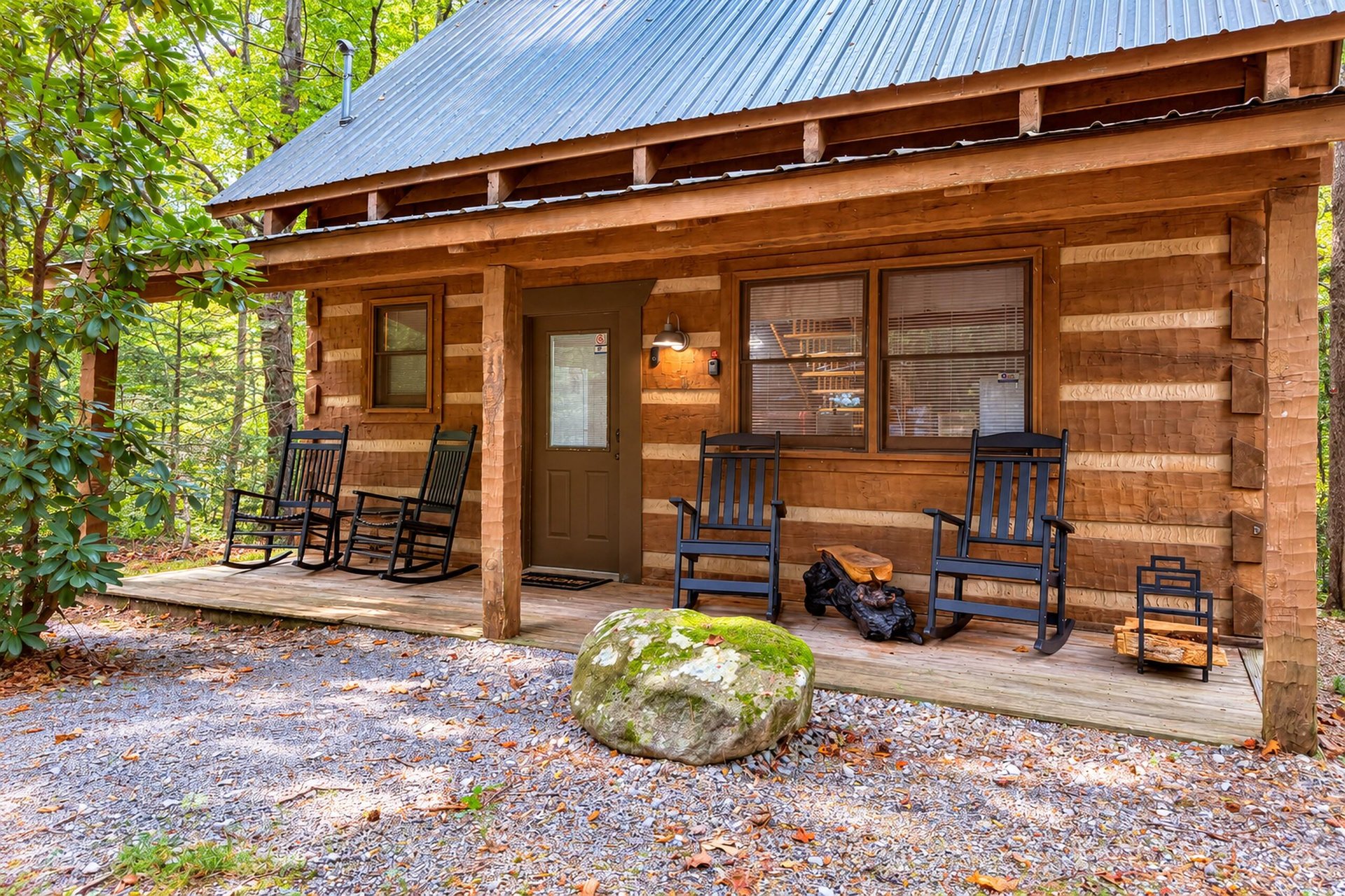 A welcoming log cabin nestled among tall trees offers a cozy front porch with rocking chairs, perfect for sipping morning coffee or unwinding after a day of exploring the forested surroundings.