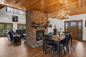Gather around the stunning stone fireplace or enjoy meals at the dining table beneath soaring wood ceilings—your perfect mountain retreat awaits.