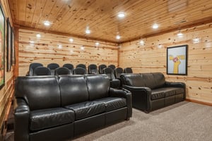 Your private theater room awaits with plush leather seating and rustic wood walls, perfect for cozy movie nights with the whole group.