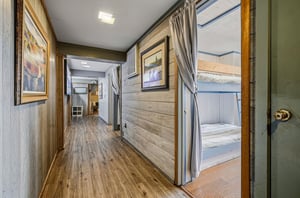 Your private hallway features warm wood details and leads to cozy bunk beds with privacy curtains for restful sleep.