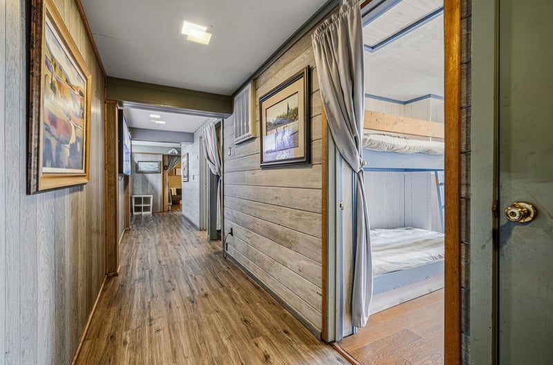 Your private hallway features warm wood details and leads to cozy bunk beds with privacy curtains for restful sleep.