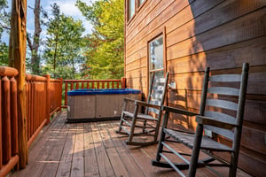 Deck seating near the hot tub at American Dream, a 2 bedroom cabin rental located in Gatlinburg