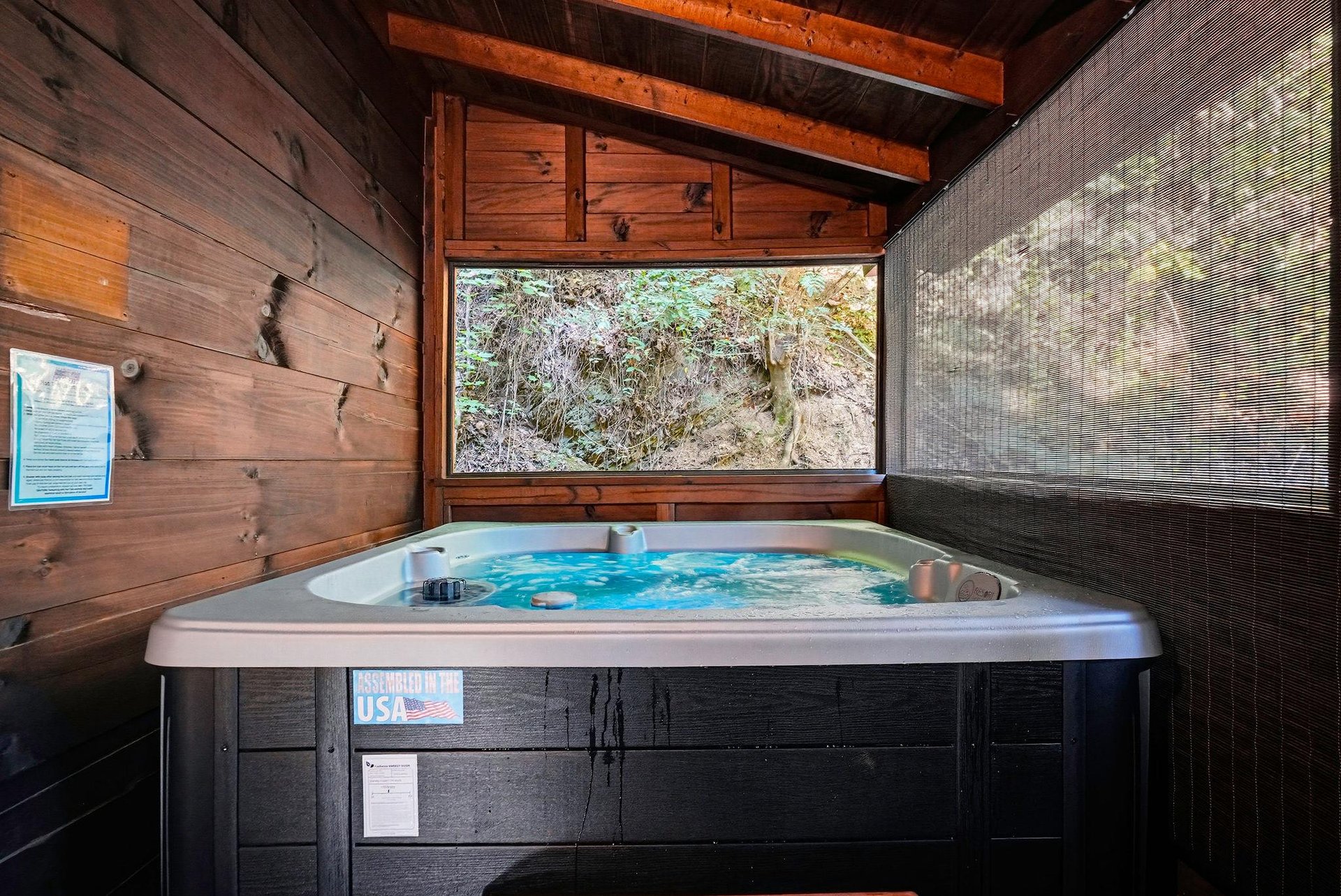 Unwind in your private hot tub beneath rustic wooden beams, with a serene natural view just beyond the window. Pure relaxation awaits you here.