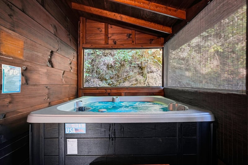 Unwind in your private hot tub beneath rustic wooden beams, with a serene natural view just beyond the window. Pure relaxation awaits you here.