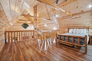 Your rustic loft bedroom features warm wood beams and cozy log bed frame for peaceful mountain retreat nights.