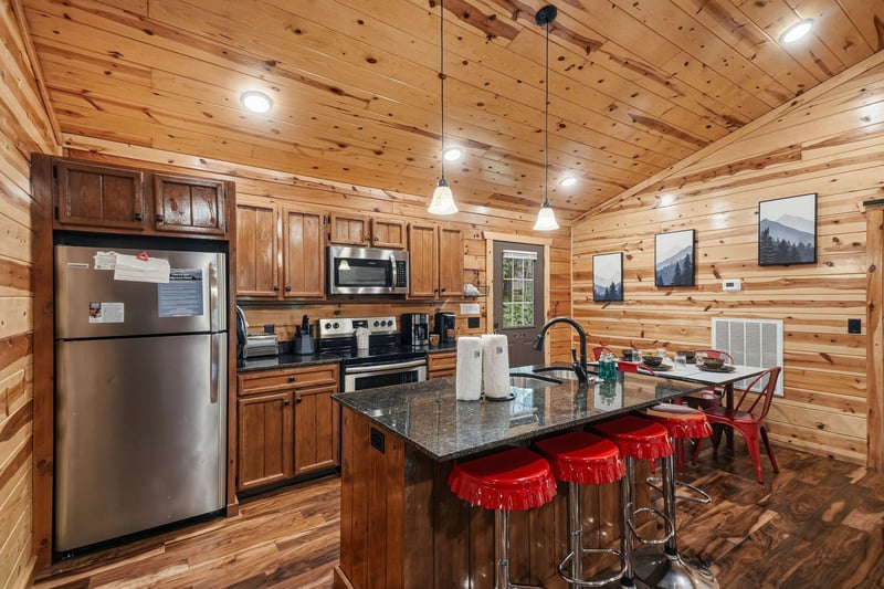 Step into your warm, woodpaneled kitchen where granite counters, stainless appliances, and a cozy breakfast island invite you to cook and gather over morning coffee.