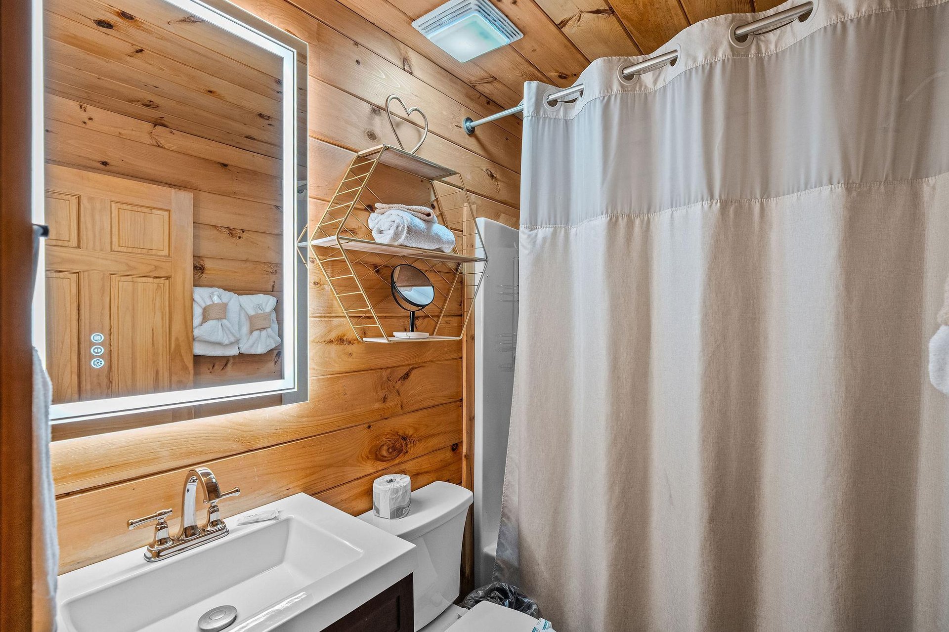 Full bathroom with lit mirror