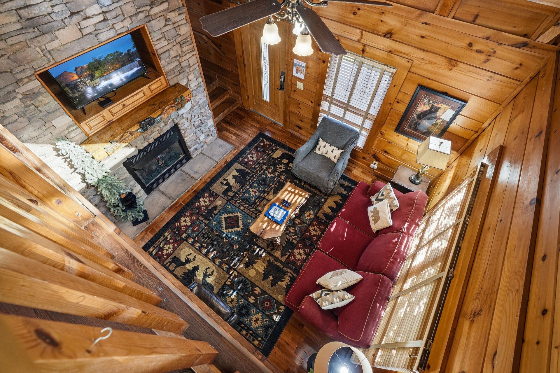 Unwind in your cozy cabin living room with rich leather seating, stone fireplace, and rustic charm throughout.