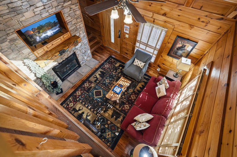 Unwind in your cozy cabin living room with rich leather seating, stone fireplace, and rustic charm throughout.