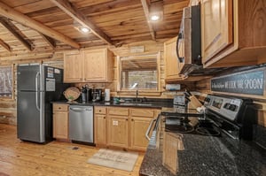 Your fullyequipped kitchen invites cozy cooking adventures with rustic wood beams, granite counters, and stainless steel appliances.