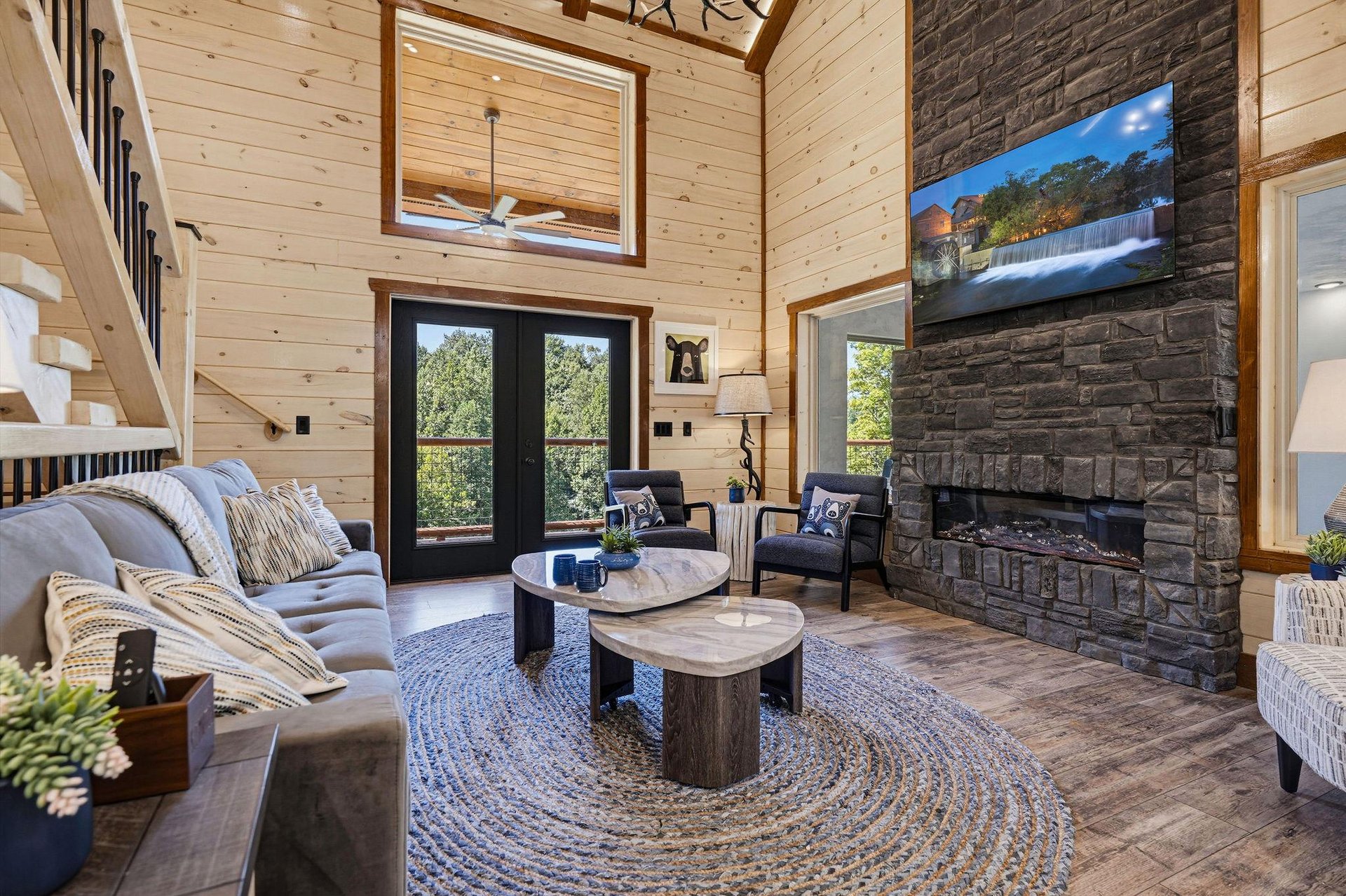 Sink into the plush sofa and feel the warmth of the stone fireplace as sunlight streams through tall windows, creating your perfect mountain retreat.