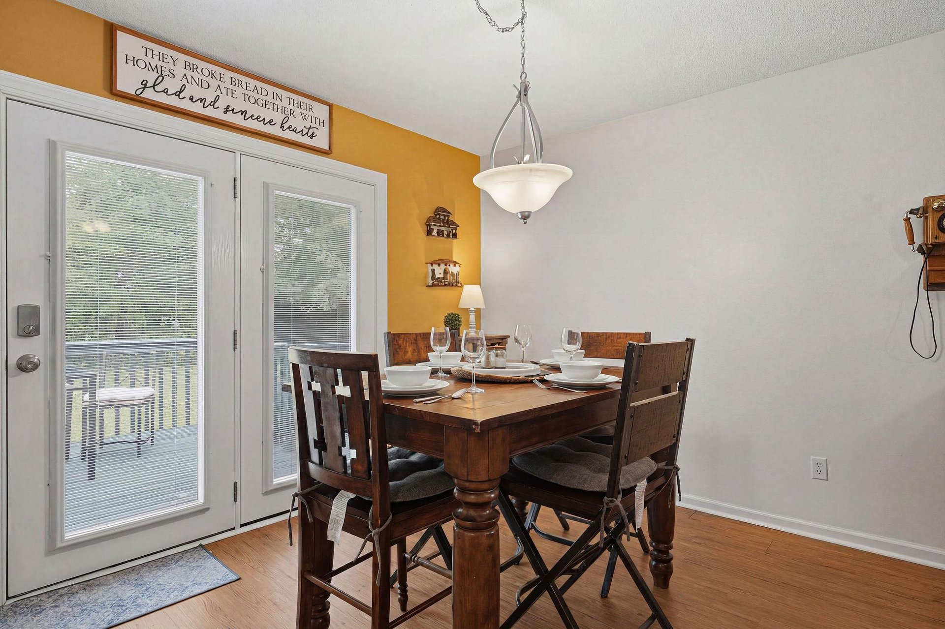 Your dining space awaits with warm lighting and a welcoming farmhouse table, perfectly set for gathering over homecooked meals and making memories together.