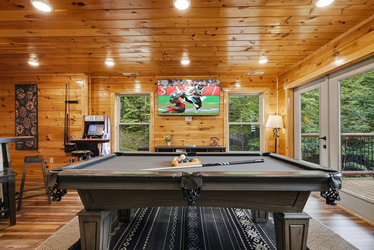 Challenge your friends to a game in this pinepaneled game room, where the pool table, bigscreen TV, and forest views create the perfect retreat for fun and relaxation.
