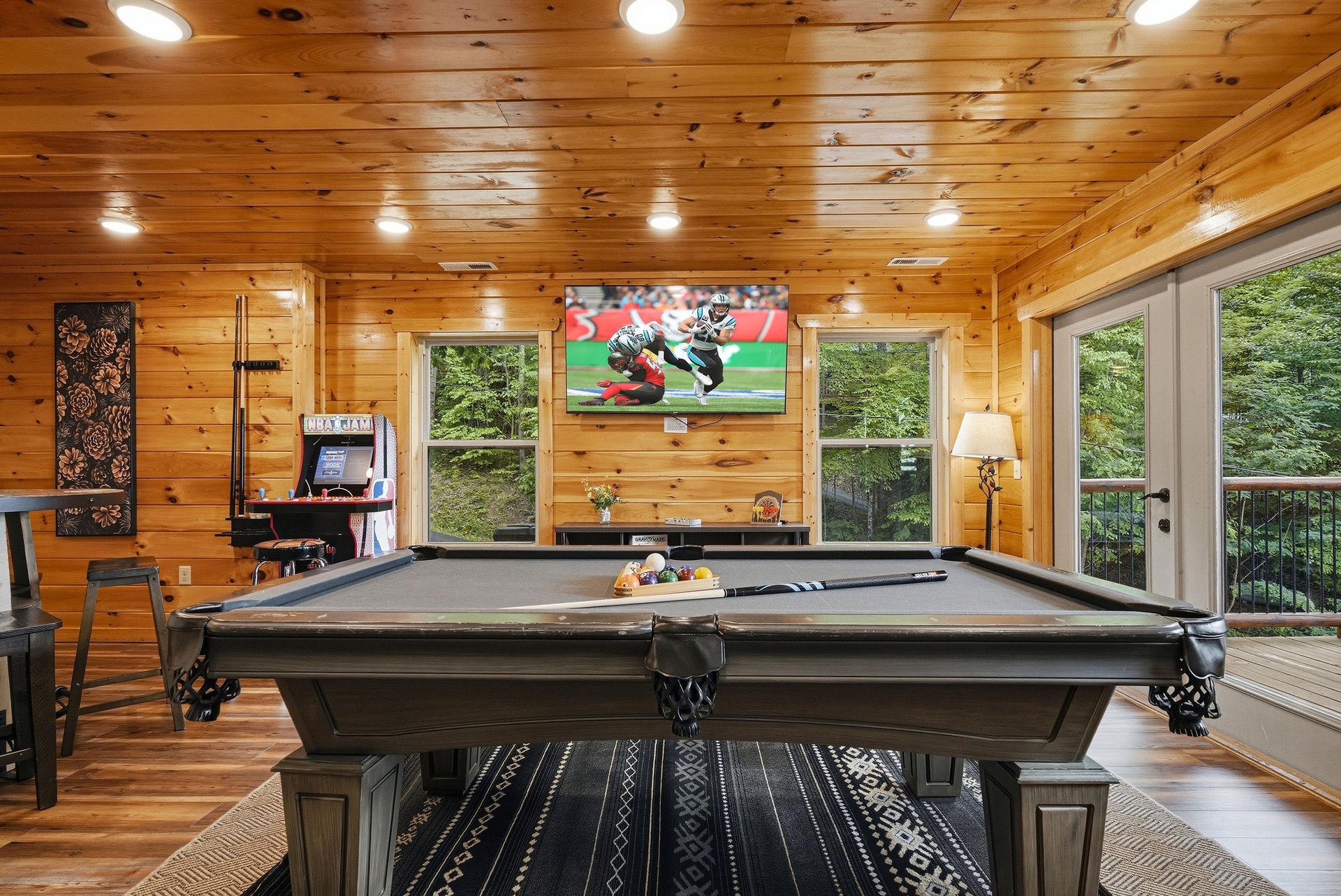Challenge your friends to a game in this pinepaneled game room, where the pool table, bigscreen TV, and forest views create the perfect retreat for fun and relaxation.