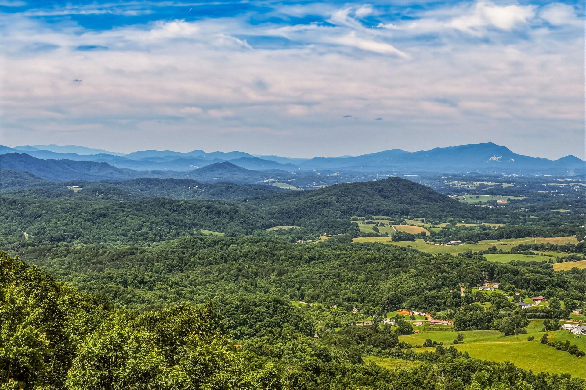 Sweeping mountain vistas stretch across forested hills and green valleys, offering a serene backdrop to the propertys natural surroundings.