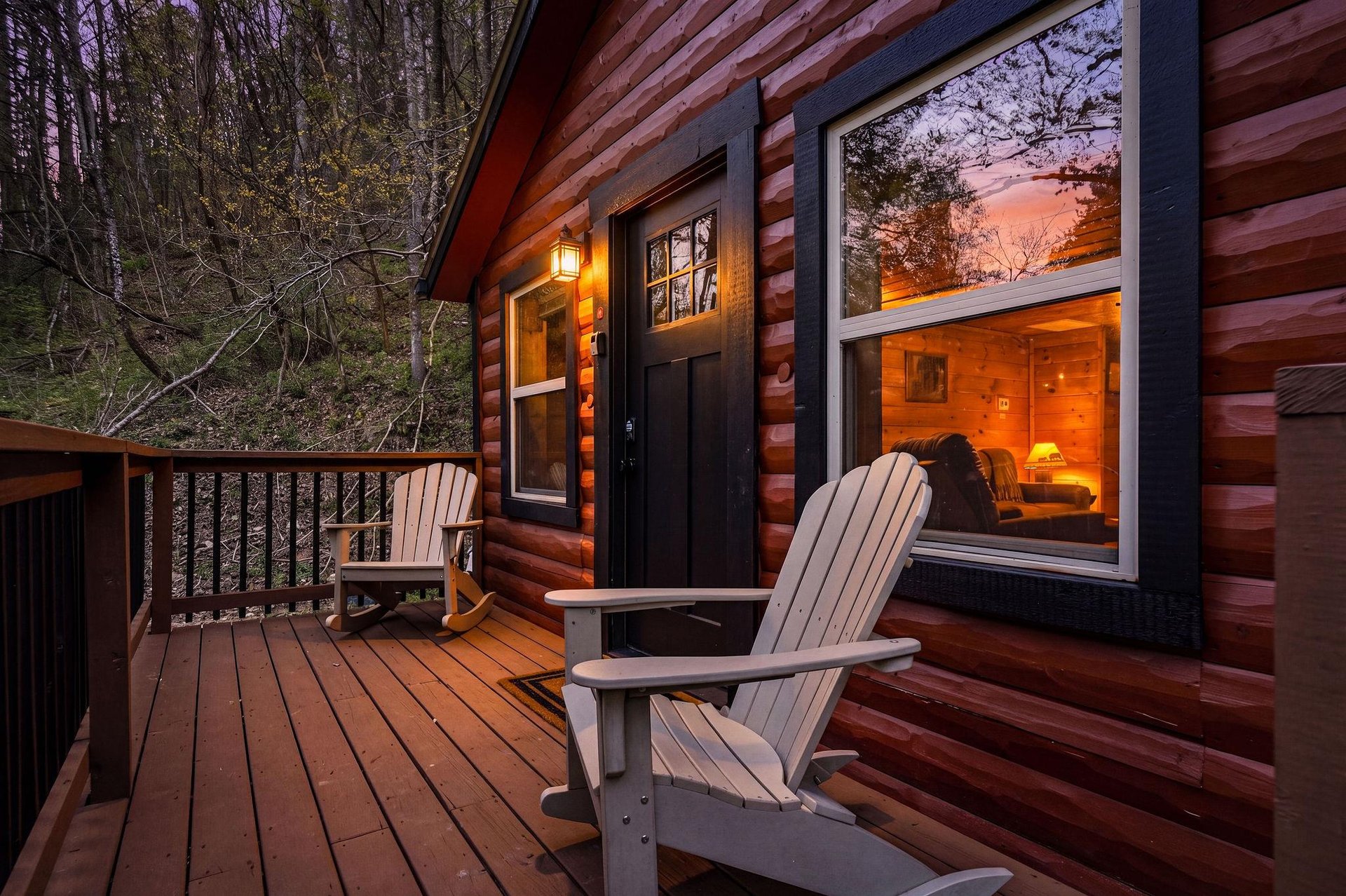 Cozy log cabin deck with Adirondack chairs where you can unwind while watching the sunset paint the sky in warm hues.