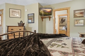 Sink into plush textures and rustic charm in your cozy bedroom. Natural wood accents and thoughtful touches create a warm retreat after a day of adventure.