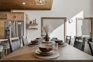 Your dining space invites memorable meals with rustic wooden table, modern chairs, and thoughtful details under warm ceiling beams.