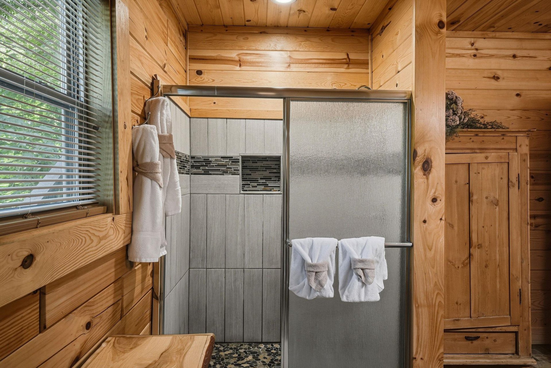 Step into your private retreat where rustic charm meets modern comfort. Fresh towels await, and natural light filters through the pines—your peaceful cabin escape begins here.