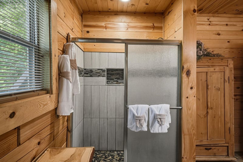 Step into your private retreat where rustic charm meets modern comfort. Fresh towels await, and natural light filters through the pines—your peaceful cabin escape begins here.