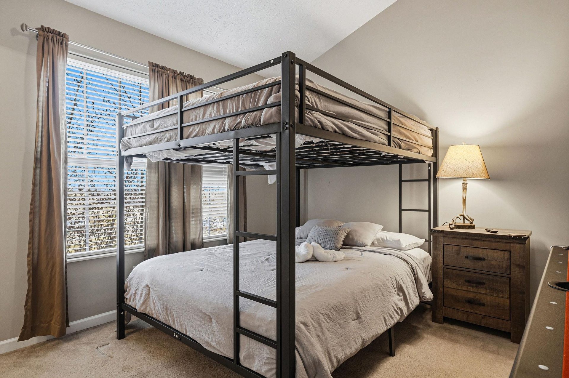 Sleep soundly in this stylish bunk bed setup with crisp linens and bedside conveniences for your restful retreat.