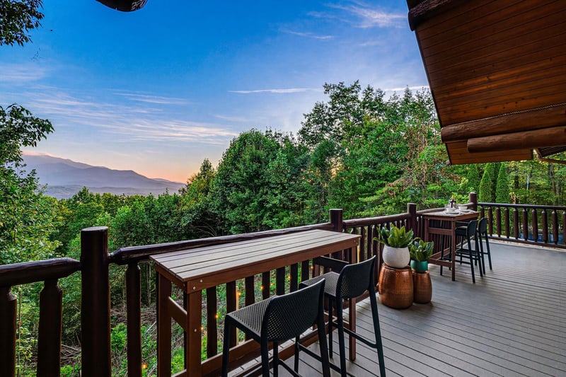 Sip your morning coffee at the outdoor bar on this spacious deck, taking in the sweeping mountain views framed by lush greenery—a perfect retreat for unwinding in natures serenity.