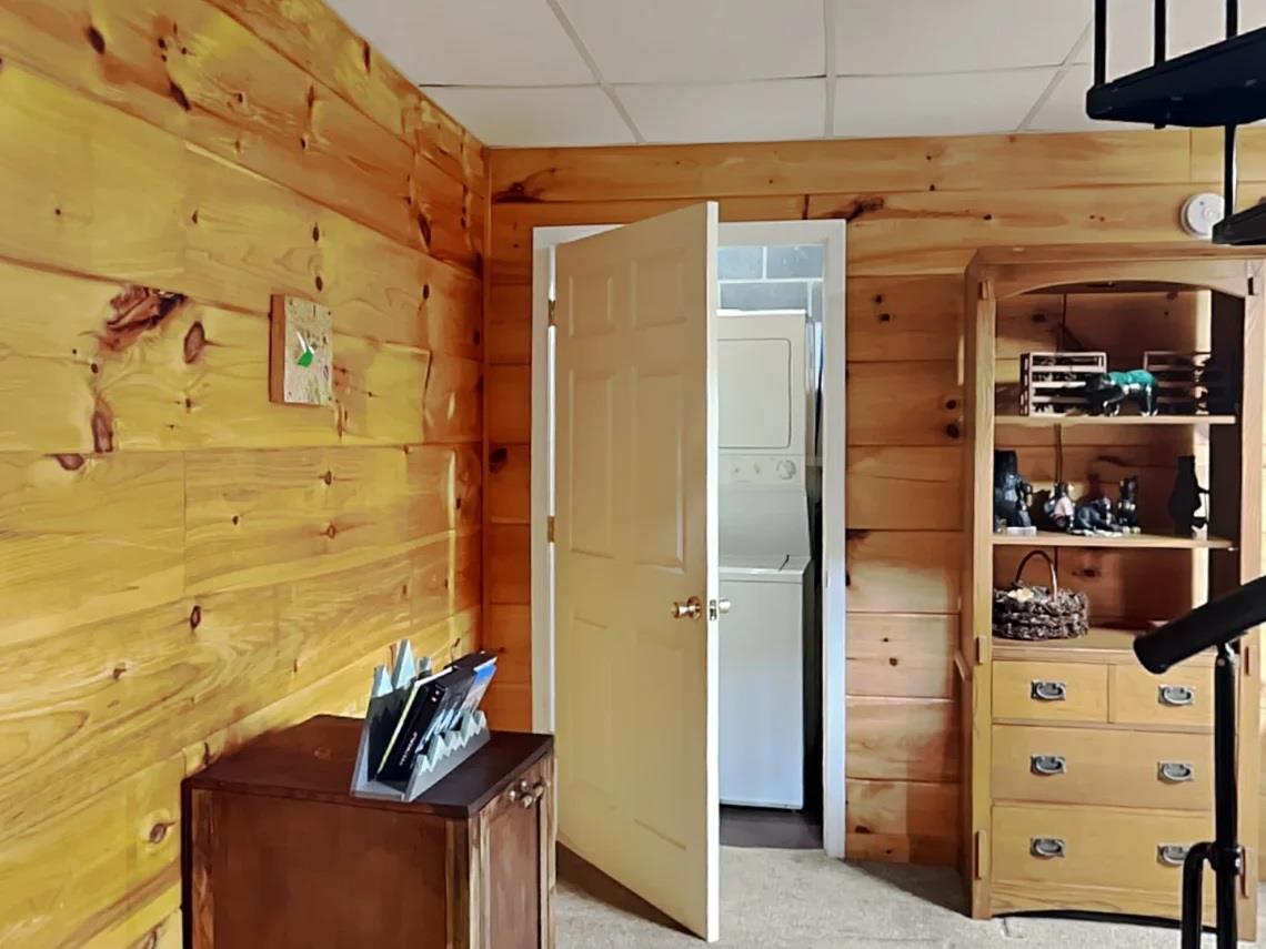 Step into your cozy cabin retreat featuring warm knotted pine walls, charming vintage storage, and a washerdryer combo for your convenience—everything you need for a comfortable mountain escape.