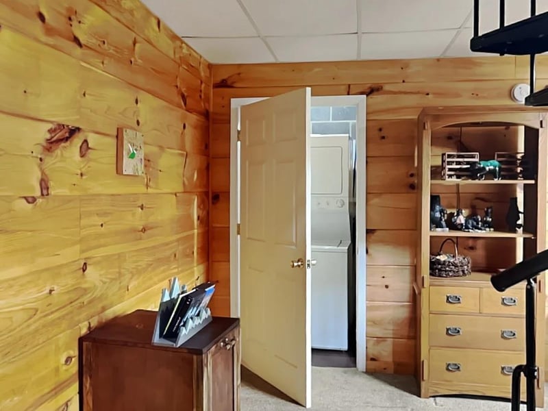 Step into your cozy cabin retreat featuring warm knotted pine walls, charming vintage storage, and a washerdryer combo for your convenience—everything you need for a comfortable mountain escape.