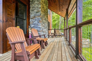 Enjoy morning coffee in your comfortable Adirondack chairs, surrounded by lush forest views and natural wood details that create a peaceful mountain retreat.