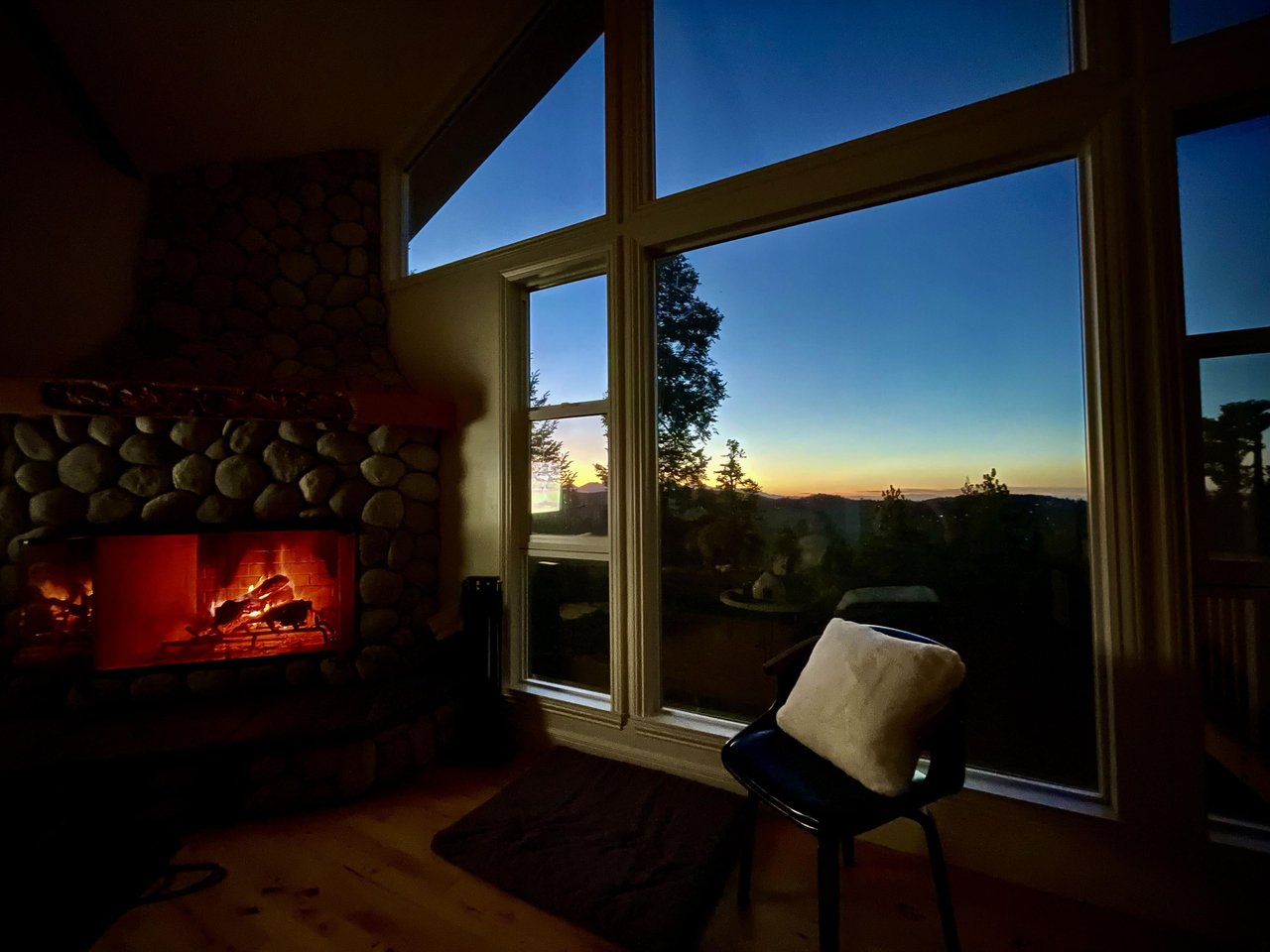 Large stone fireplace, ample seating, and easy access to the kitchen and dining area.