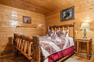 Cozy bedroom with rustic log bed and warm woodpaneled walls invites you to unwind in mountain cabin charm. Soft lighting and handcrafted furniture create your peaceful retreat.