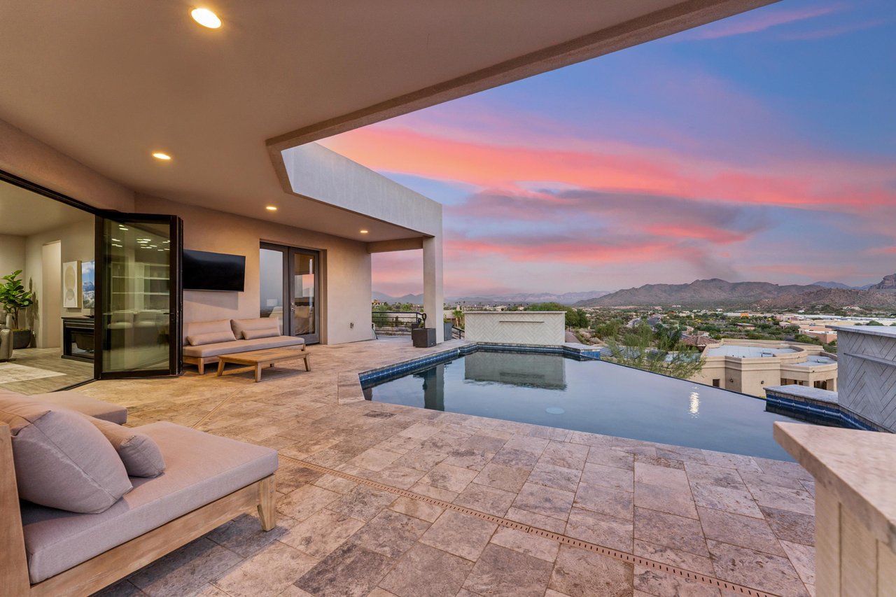 Infinity pool overlooking the mountains, outdoor TV, BBQ, firepit, and outdoor seating.