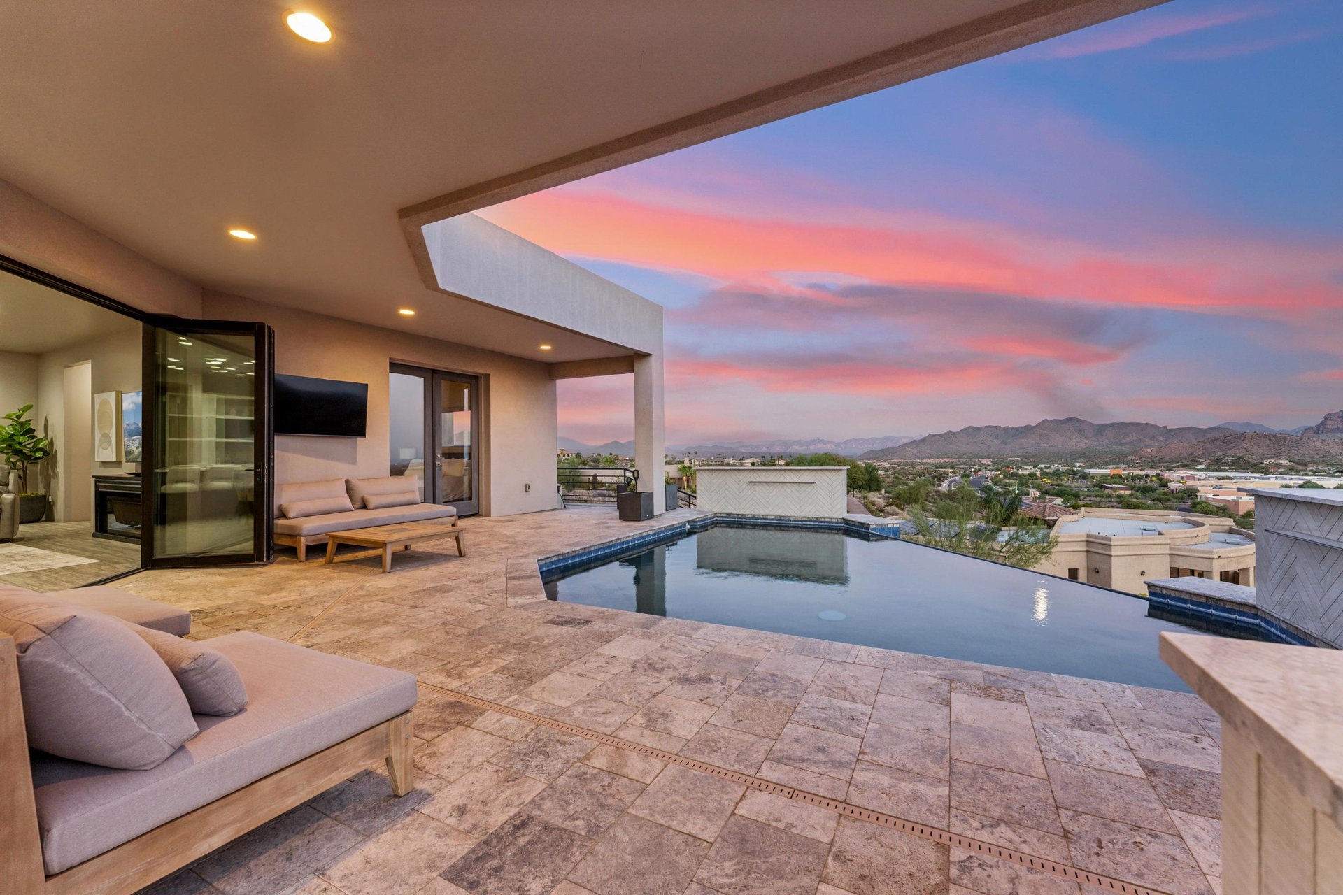 Infinity pool overlooking the mountains, outdoor TV, BBQ, firepit, and outdoor seating.