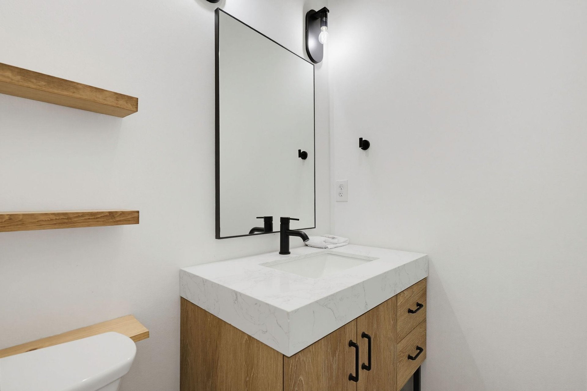 Refresh in your sleek private bathroom with modern marble countertop and warm wood accents, combining style and comfort for your stay.